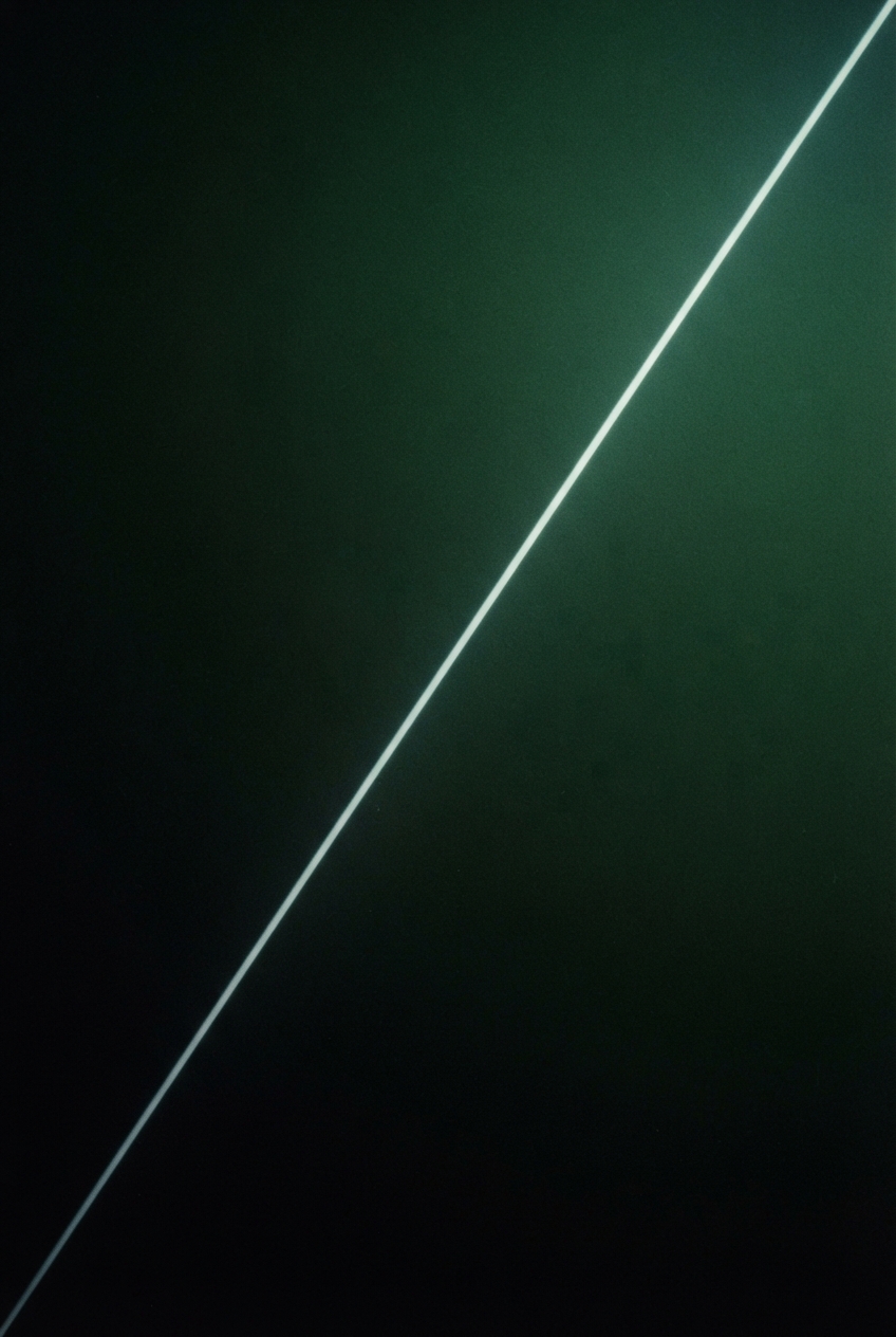 A glowing pale diagonal line crosses a dark green-to-black textured background from bottom left to top right.